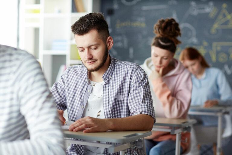 Des personnes passent un examens dans une salle de formation